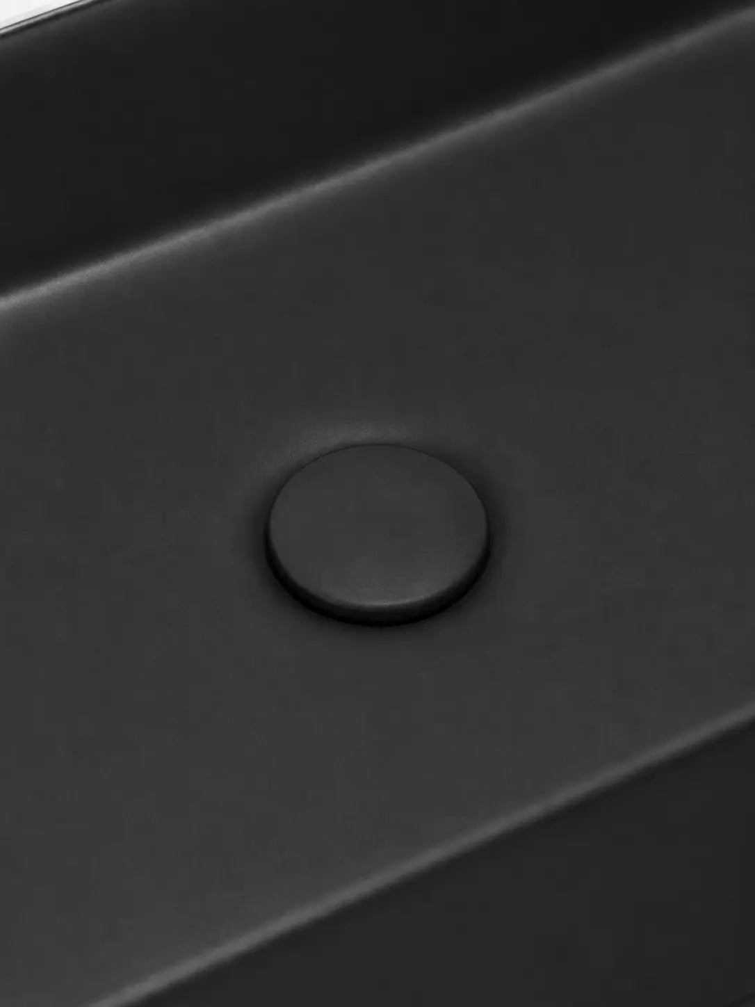 Close-up of the coordinated matte black ceramic drain cover on BBbidet 2605 basin