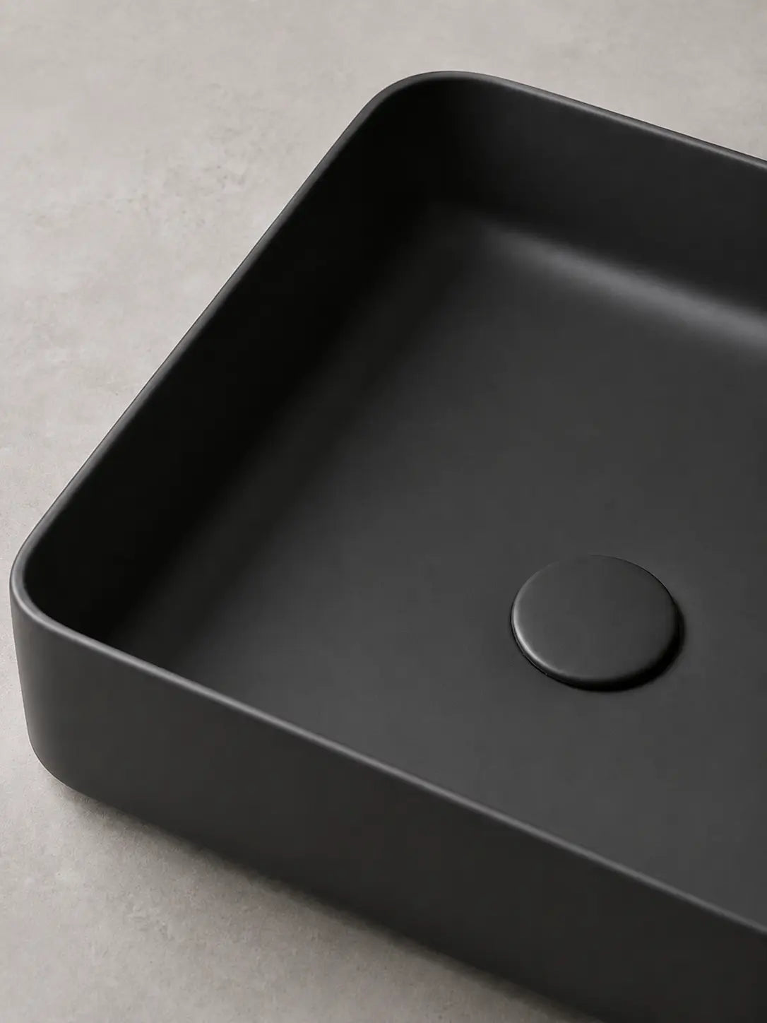 Close-up of the coordinated matte black ceramic drain cover on BBbidet 2620 basin