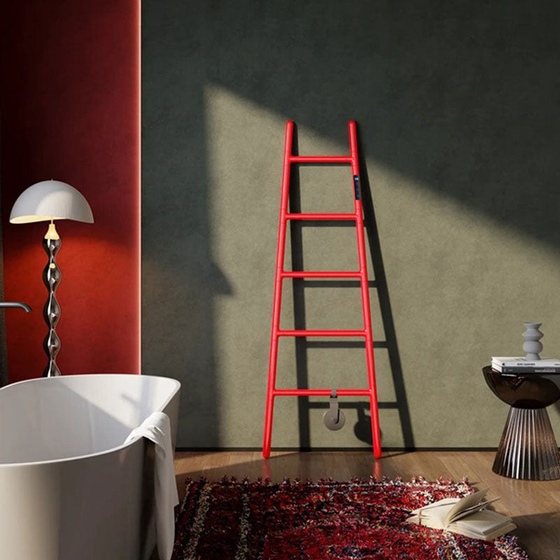 An artistic lifestyle shot of a vibrant red ladder-style electric heated towel rack casting a shadow on a textured olive green wall in a luxurious bathroom with a white bathtub and a crimson accent wall