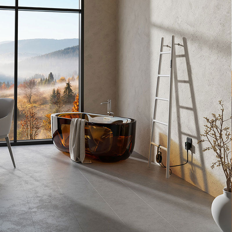 A luxury resort-style bathroom featuring a white ladder electric heated towel warmer casting a long shadow on a textured wall, next to a translucent amber resin bathtub by a floor-to-ceiling window overlooking misty mountains.